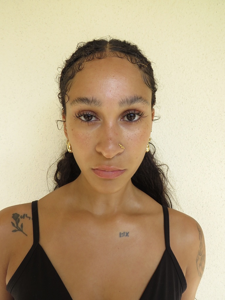 Digital — front-facing headshot, hair pulled back, natural makeup