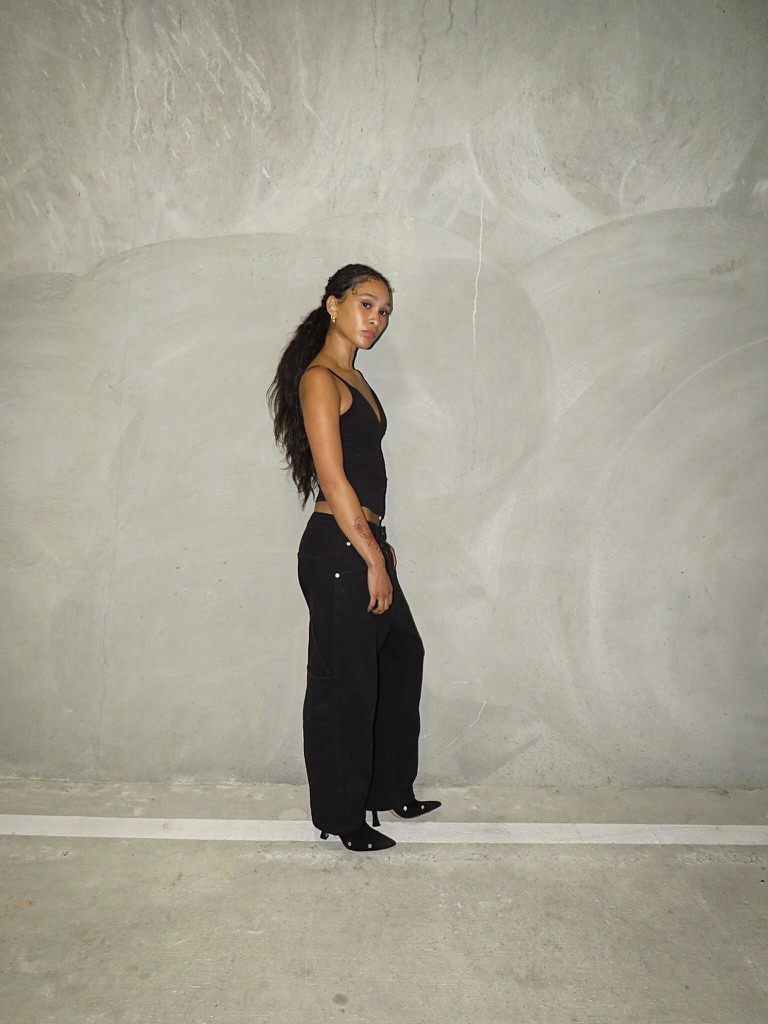 Digital — full-length side profile against a concrete wall