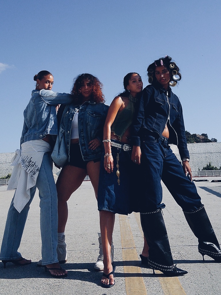 Four models in Gap denim posing on a sunlit rooftop