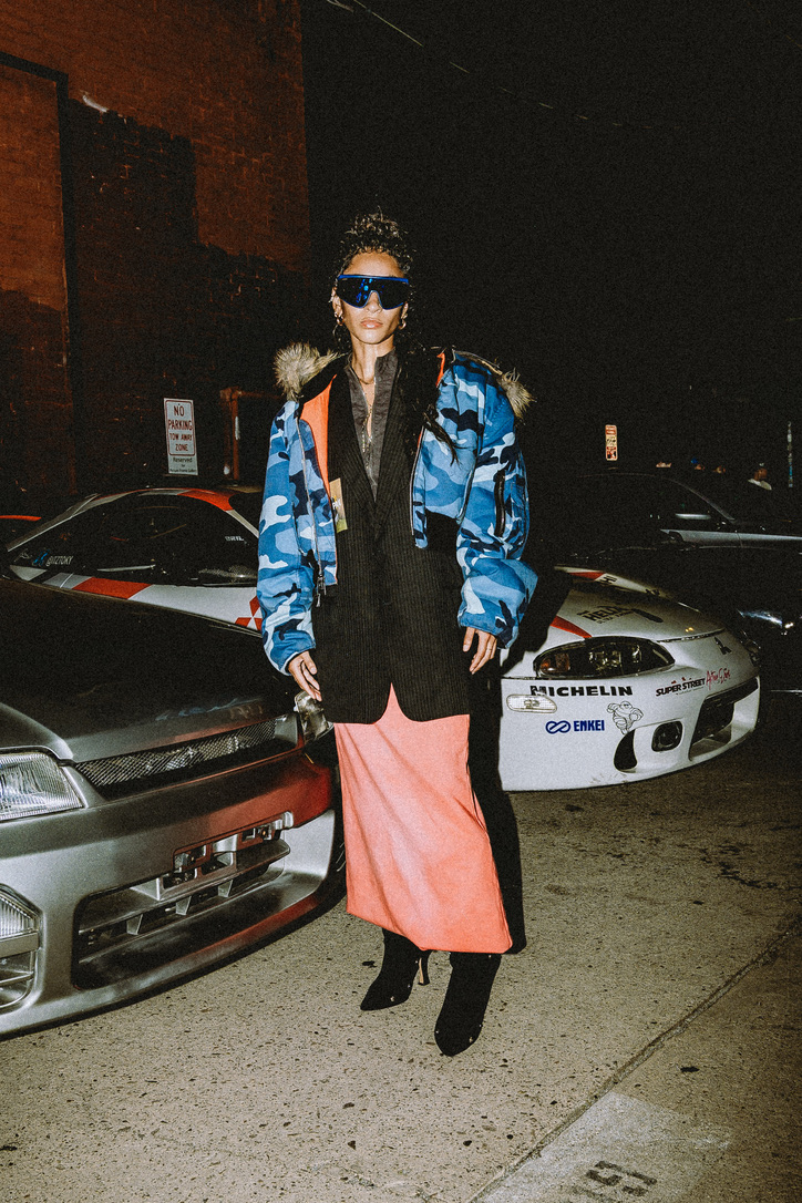 Maria Williams at night in a blue camo bomber, pinstripe blazer, and coral skirt for Lab 74