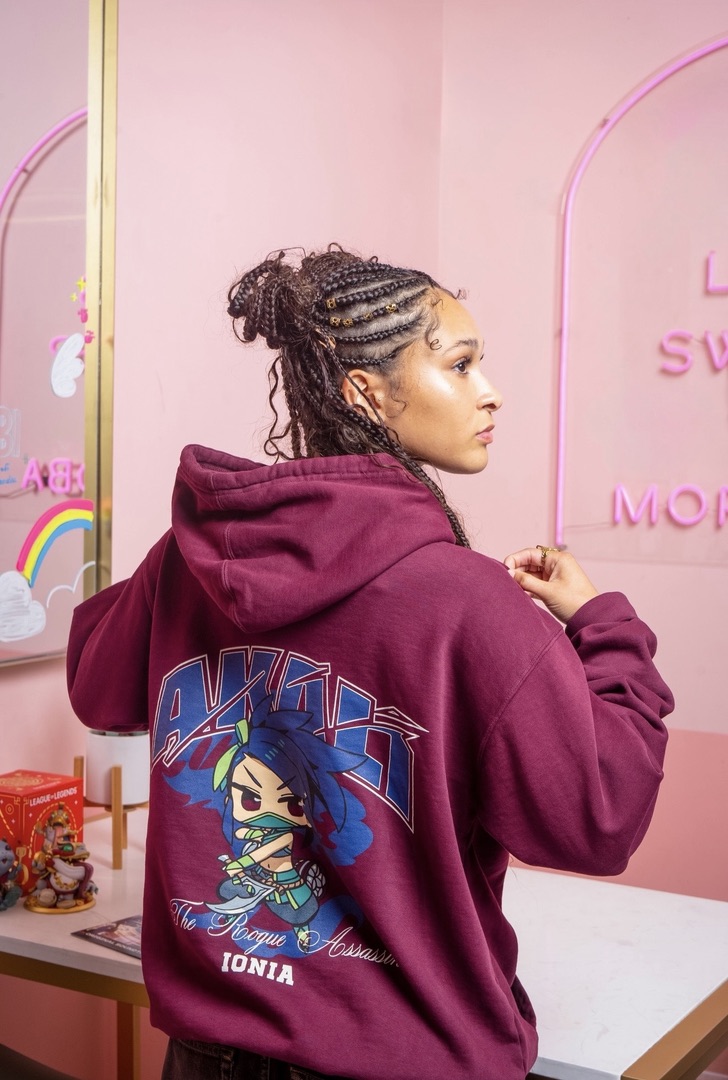 Maria Williams in a maroon League of Legends Akali hoodie in a pink set